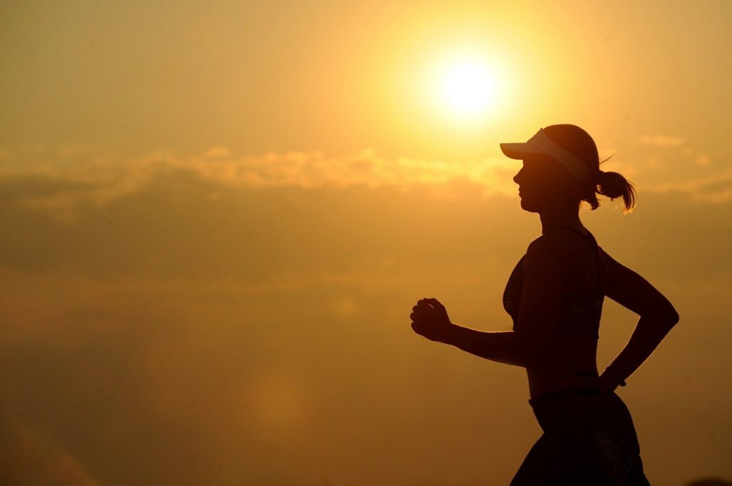 夕陽に照らされてマラソンする女性

